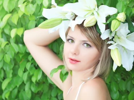 Close-up portrait of young beautiful woman with lily flowers