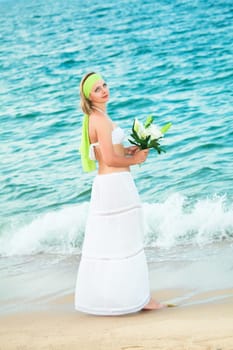 Beautiful woman near the sea with flowers