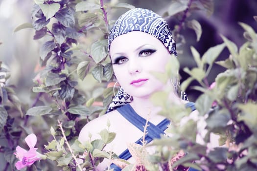 Young woman with creative make-up at flower garden