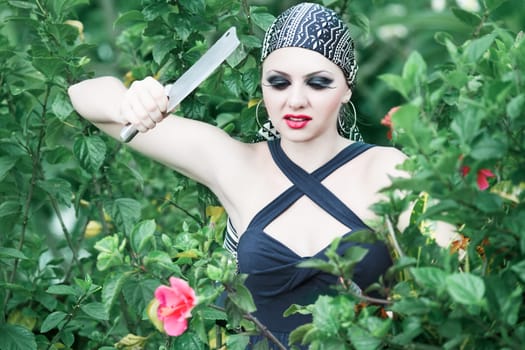 Woman in garden cut flowers with a knife