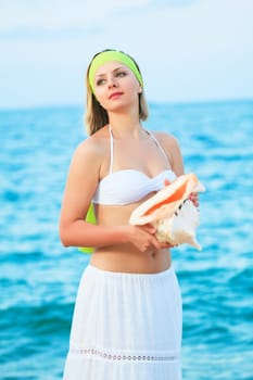 Young beautiful woman with seashell in her hands