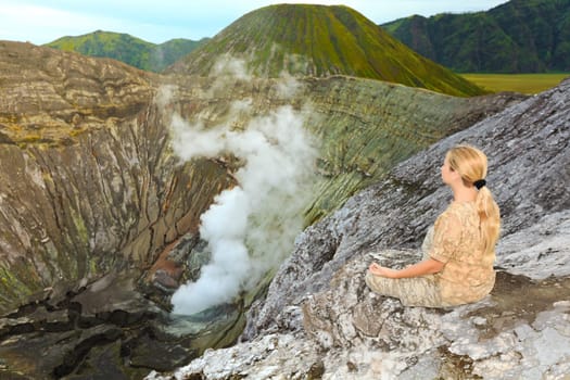 Woman meditating at the crater of volcano Bromo. Java. Indonesia