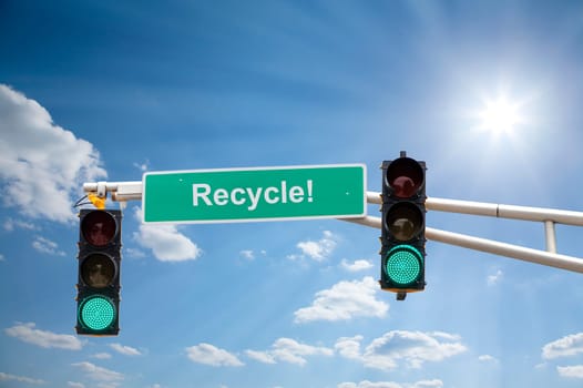 Image of a street sign and traffic lights with blue sunny skies in the background