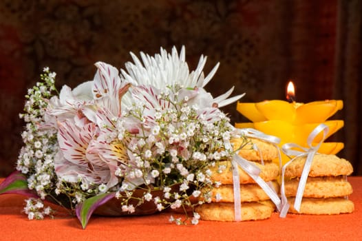 Bouquet of flowers and cookies on an orange background