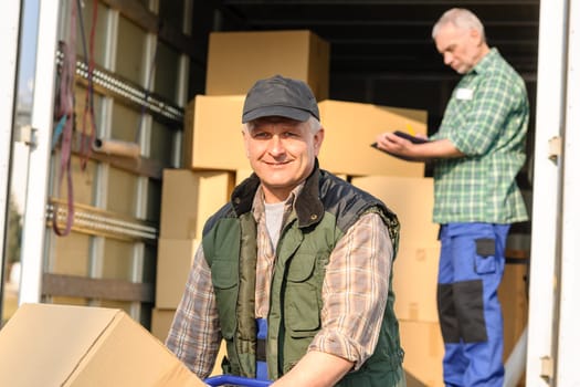 Male mover loading van with cardboard box delivery service