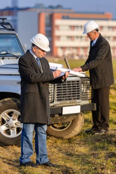 Male architect developers on construction site making notes building project