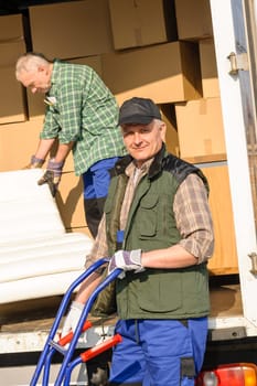 Two movers man loading furniture and boxes from truck vehicle