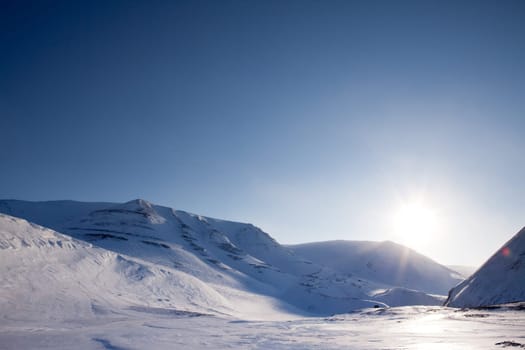 A dramatic winter landscape with snow and mountains