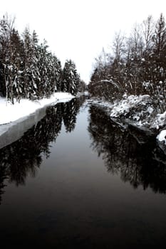 A cold winter river with a grey sky