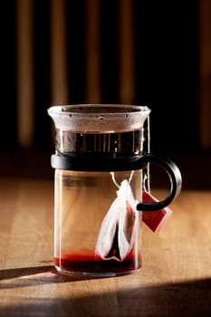 A tea bag in a cup of hot water with strong directional morning light