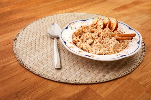 A bowl of porridge with apple and cinnamon spices