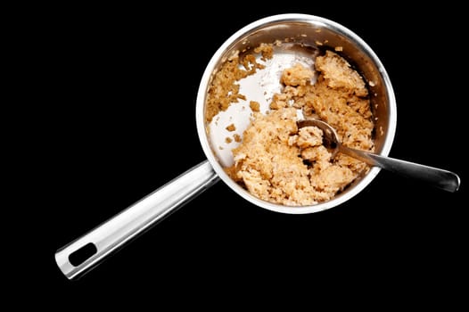 A pot of old cold porridge isolated on black