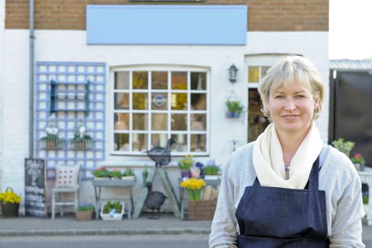 Florist standing outside her shop smiling at camera