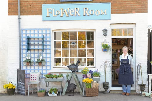 Florist standing outside her shop smiling at camera