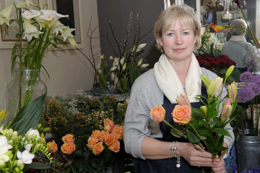 Florist holding a bouquet of flowers in her shop