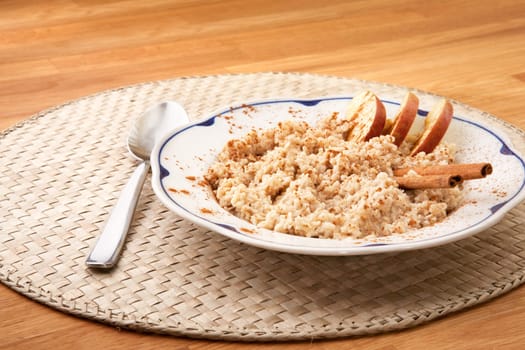 A bowl of porridge with apple and cinnamon spices