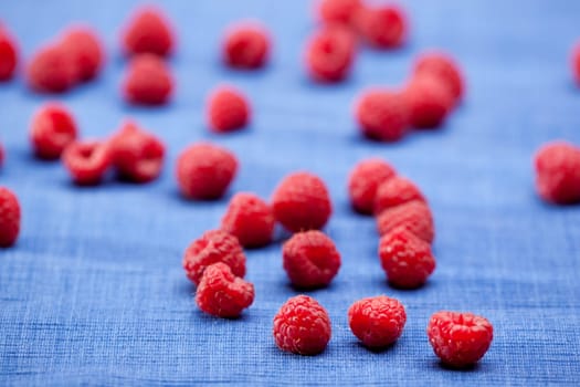 Fresh raspberries isolated on a blue cloth