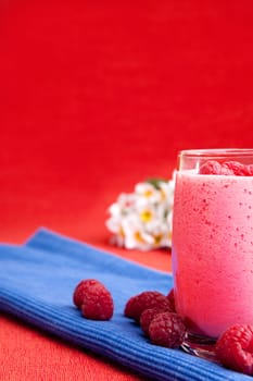 A healthy berry drink - raspberry smoothie on red