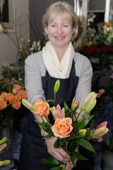 Florist picking flowers from her shop to make a bouquet