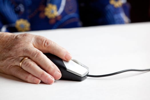 An elderly hand on a computer mouse