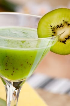 A tasty kiwi smoothie in a natural setting with macro detail on kiwi slice
