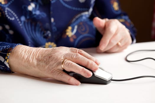 An elderly hand on a computer mouse