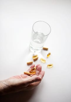 An elderly hand with a variety of large pills - shallow depth of field, focus on hand and pills