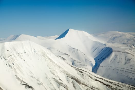 A snow covered mountain range in Svalbard