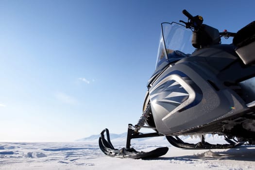 A snowmobile detail on a barren winter landscape