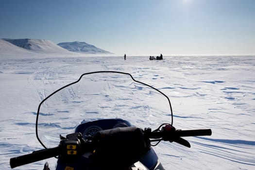 Three snowmobiles on an outdoor winter landscape