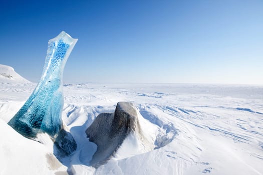 A piece of glacial ice sticking out of the frozen ocean, Spitsbergen, Svalbard, Norway