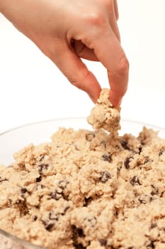 A hand grabbing a test taste of cookie dough