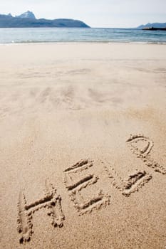 Help written in the sand on a deserted island