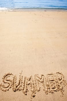 The word summer written in the sand at a beach