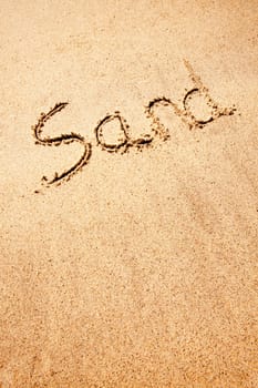 A sand background image with the word written with a stick