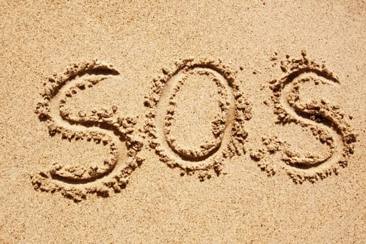 S.O.S written in the sand with a finger or stick
