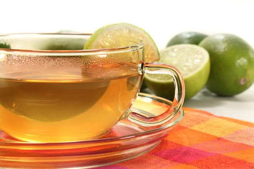 a cup of lime tea with fresh limes