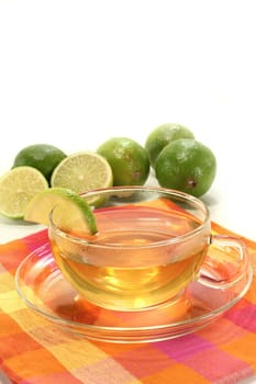 a cup of lime tea with fresh limes