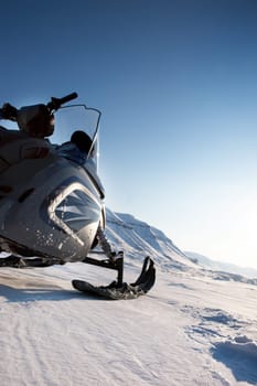 A snowmobile detail on a barren winter landscape