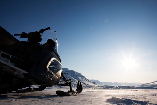 A snowmobile detail on a barren winter landscape