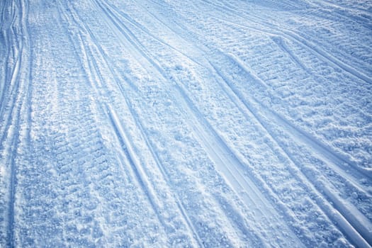 A snow texture of snowmobile tracks converging into the distance