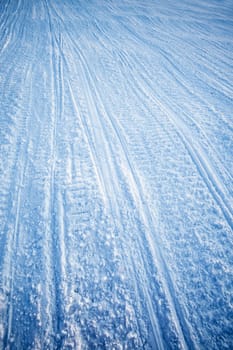 A snow texture of snowmobile tracks converging into the distance