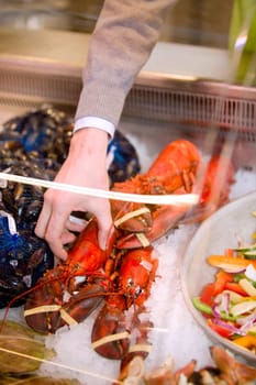 A freshly cooked lobster in a grocery store seafood display