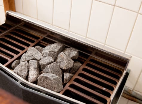 Close-up detail of a steam sauna heater with rocks