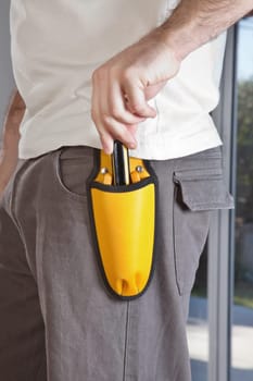 Mid section of man holding his tool pouch