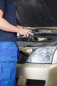 Detail of a mechanic looking at work order on digital tablet