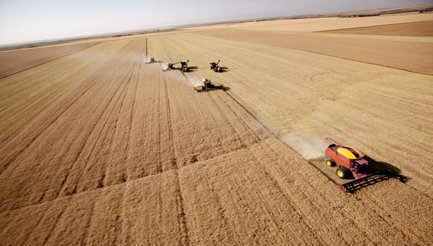 Combines on prairie landscape driving in formation