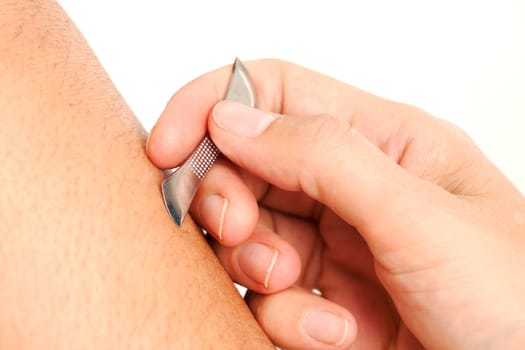 Detail of a Choto, a Japanese Pediatric Acupuncture tool being used on the leg of a young male.