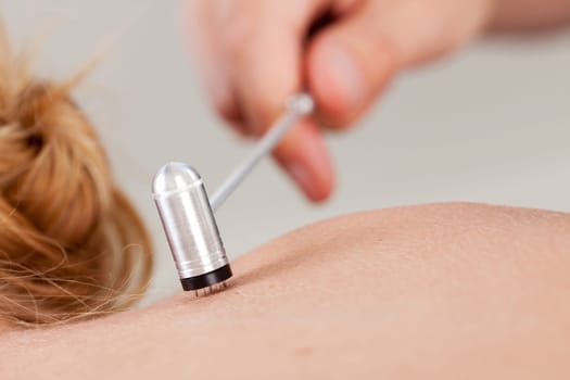 Detail of plum blossom tool on back of female patient