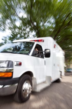 Motion blur of ambulance speeding with female paramedic driving